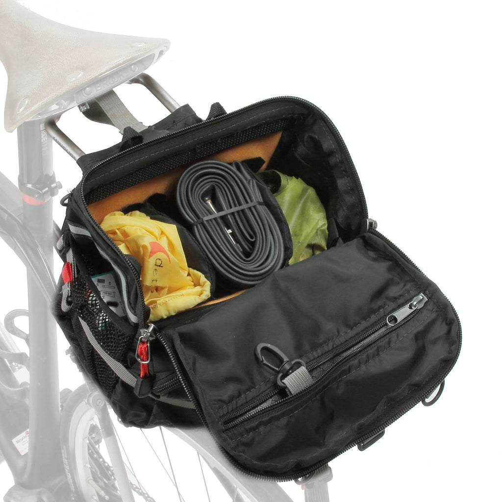The main “reverse opening” lid opens away from the saddle. Optional dividers keep gear separate. Snaphook inside the zippered lid pocket is for keys.
