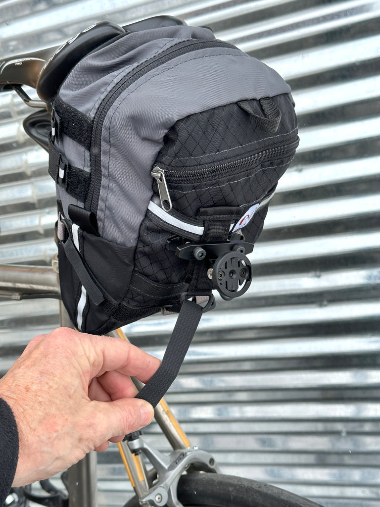 STEP 4 (optional): If you find your Varia needs more stability, slip the piece of OmniTape Velcro through the D-ring on the adapter and attach there other end lower on the bag. Or, if you are having trouble centering the Varia (left & right), causing it to aim off center on the road, try this strap to tug it to one side or another.