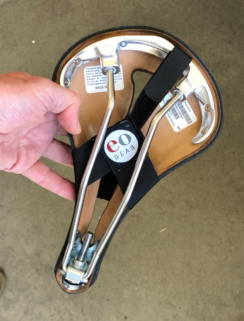 INSTRUCTIONS: Attach so the eoGEAR label is facing you, as shown. Slip the narrow Velcro-like strap through the back of the saddle. Cinching this strap tighter will yield a narrower profile.