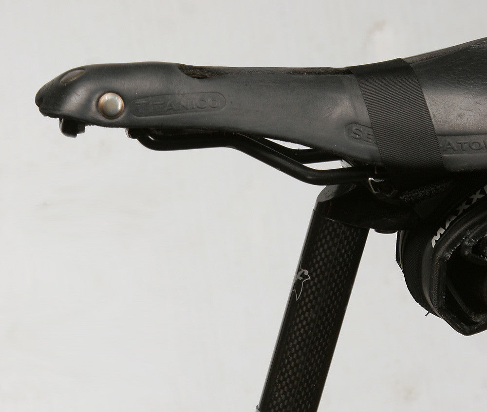 The “over the top” strap squeezes the sides of the leather, making its shape more like a conventional shaped saddle.